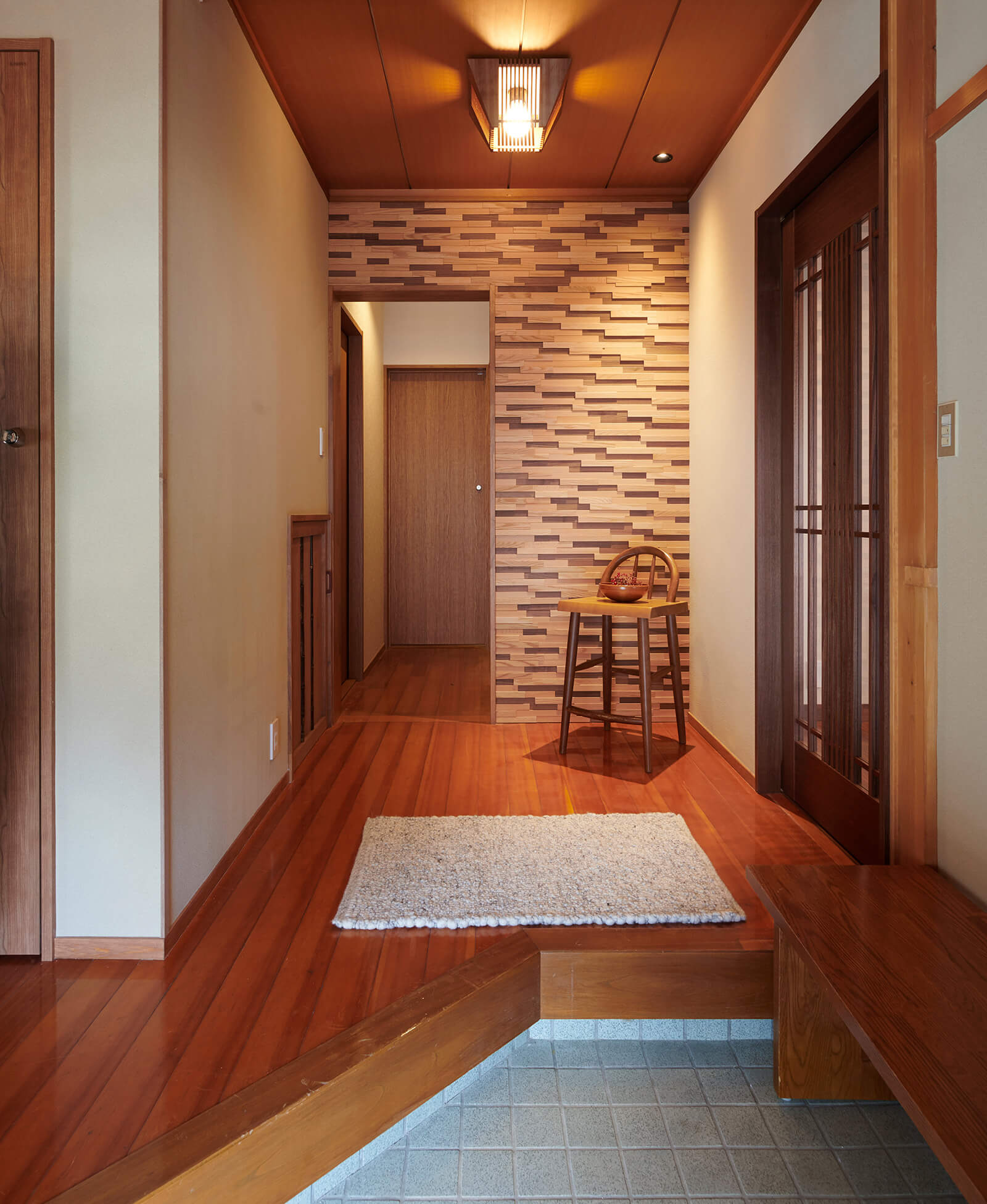 玄関ホールを隔ててリビング、和室、浴室、トイレへ繋がります。壁は天然木のタイル